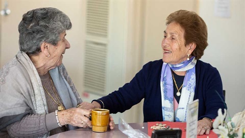 two older women talking at table