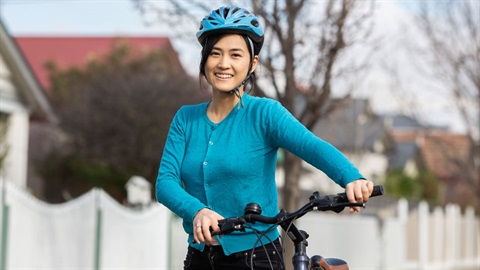 Female bike rider standing with bike in residential street