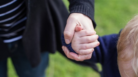 a man holding a child's hand