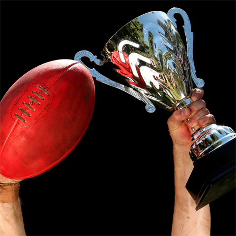 person holding trophy AFL