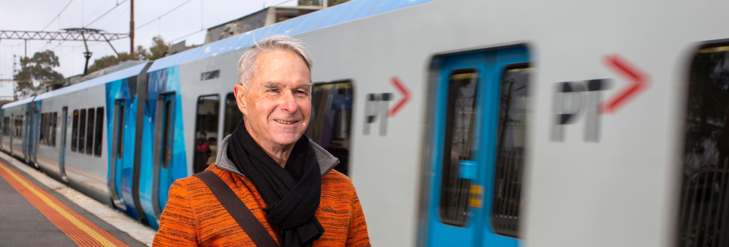 Older man at a train station.png